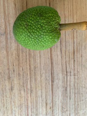 Moraceae ailesinin tüm ekmek meyvesi üyeleri Artocarpus altilis ve dilimler ahşap yüzeyde sergilenir. Nişastalı, patates gibi kızarmasıyla tanınır. yiyecek fotoğrafçılığı, meyve fotoğrafçılığı yiyecek ve içecek.