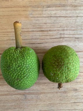 Moraceae ailesinin tüm ekmek meyvesi üyeleri Artocarpus altilis ve dilimler ahşap yüzeyde sergilenir. Nişastalı, patates gibi kızarmasıyla tanınır. yiyecek fotoğrafçılığı, meyve fotoğrafçılığı yiyecek ve içecek.