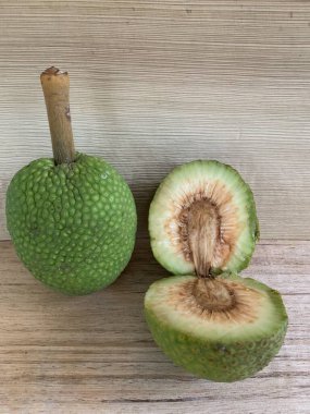 Moraceae ailesinin tüm ekmek meyvesi üyeleri Artocarpus altilis ve dilimler ahşap yüzeyde sergilenir. Nişastalı, patates gibi kızarmasıyla tanınır. yiyecek fotoğrafçılığı, meyve fotoğrafçılığı yiyecek ve içecek.