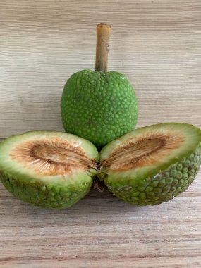 Moraceae ailesinin tüm ekmek meyvesi üyeleri Artocarpus altilis ve dilimler ahşap yüzeyde sergilenir. Nişastalı, patates gibi kızarmasıyla tanınır. yiyecek fotoğrafçılığı, meyve fotoğrafçılığı yiyecek ve içecek.