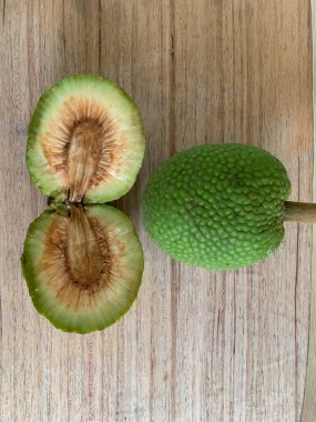 Moraceae ailesinin tüm ekmek meyvesi üyeleri Artocarpus altilis ve dilimler ahşap yüzeyde sergilenir. Nişastalı, patates gibi kızarmasıyla tanınır. yiyecek fotoğrafçılığı, meyve fotoğrafçılığı yiyecek ve içecek.