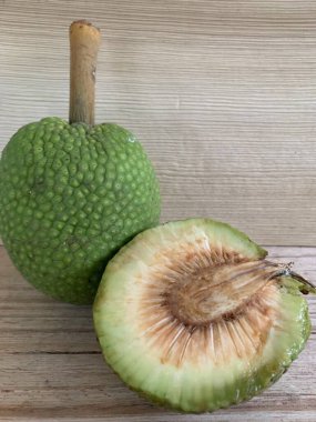 Moraceae ailesinin tüm ekmek meyvesi üyeleri Artocarpus altilis ve dilimler ahşap yüzeyde sergilenir. Nişastalı, patates gibi kızarmasıyla tanınır. yiyecek fotoğrafçılığı, meyve fotoğrafçılığı yiyecek ve içecek.