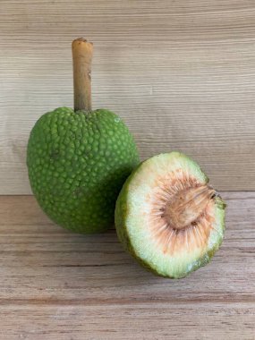 Moraceae ailesinin tüm ekmek meyvesi üyeleri Artocarpus altilis ve dilimler ahşap yüzeyde sergilenir. Nişastalı, patates gibi kızarmasıyla tanınır. yiyecek fotoğrafçılığı, meyve fotoğrafçılığı yiyecek ve içecek.