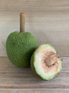 Moraceae ailesinin tüm ekmek meyvesi üyeleri Artocarpus altilis ve dilimler ahşap yüzeyde sergilenir. Nişastalı, patates gibi kızarmasıyla tanınır. yiyecek fotoğrafçılığı, meyve fotoğrafçılığı yiyecek ve içecek.