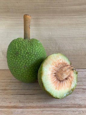 Moraceae ailesinin tüm ekmek meyvesi üyeleri Artocarpus altilis ve dilimler ahşap yüzeyde sergilenir. Nişastalı, patates gibi kızarmasıyla tanınır. yiyecek fotoğrafçılığı, meyve fotoğrafçılığı yiyecek ve içecek.