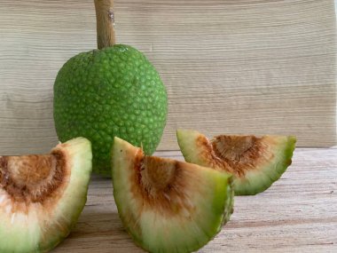 Moraceae ailesinin tüm ekmek meyvesi üyeleri Artocarpus altilis ve dilimler ahşap yüzeyde sergilenir. Nişastalı, patates gibi kızarmasıyla tanınır. yiyecek fotoğrafçılığı, meyve fotoğrafçılığı yiyecek ve içecek.