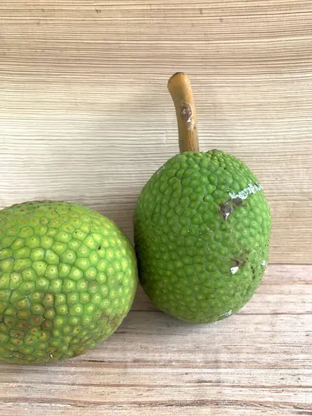 Moraceae ailesinin tüm ekmek meyvesi üyeleri Artocarpus altilis ve dilimler ahşap yüzeyde sergilenir. Nişastalı, patates gibi kızarmasıyla tanınır. yiyecek fotoğrafçılığı, meyve fotoğrafçılığı yiyecek ve içecek.