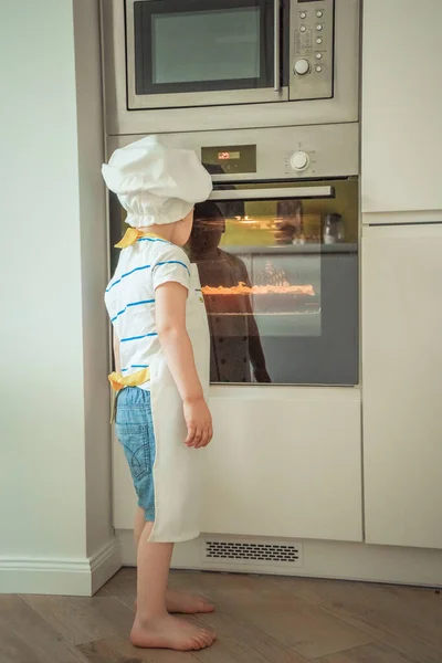 Uma Criança Chapéu Chef Avental Fica Frente Forno Estilo Vida — Fotografia de Stock
