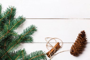 Noel kompozisyonu. Örülmüş battaniye, çam kozalakları, tahta beyaz arka planda köknar dalları. Düz yatış, üst görünüm