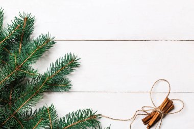 Noel kompozisyonu. Örülmüş battaniye, çam kozalakları, tahta beyaz arka planda köknar dalları. Düz yatış, üst görünüm