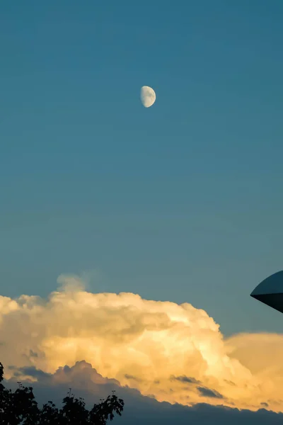 Günbatımında göksel manzara kümülonimbus bulutları ve ay.
