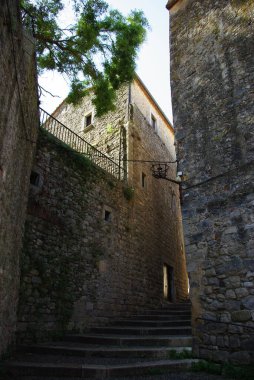 İçinde eski bir taş kule bulunan, birden fazla katlı yüksek bir bina..