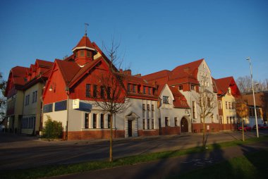 Gün batımında bir köyde kırmızı çatılı bir bina.