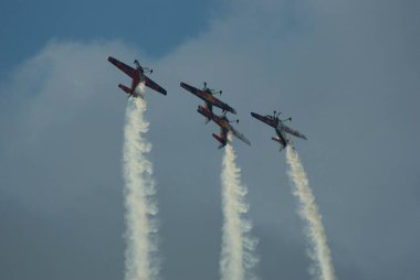 Dört uçak yan yana uçuyor, arkalarında duman bulutu bırakıyor..
