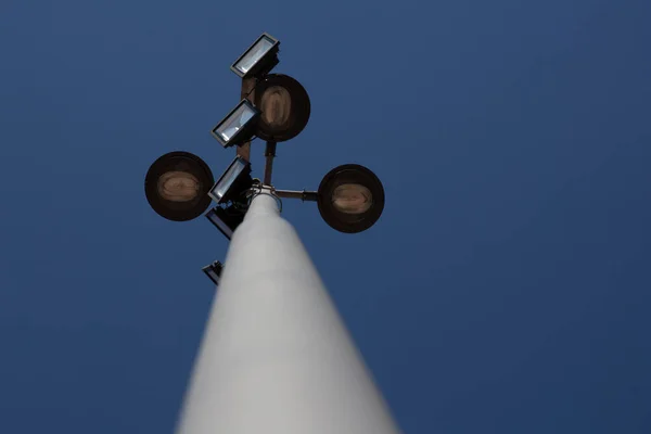 Street lighting pole in perspective. depicting a bottom-up view angle with blue sky in the background