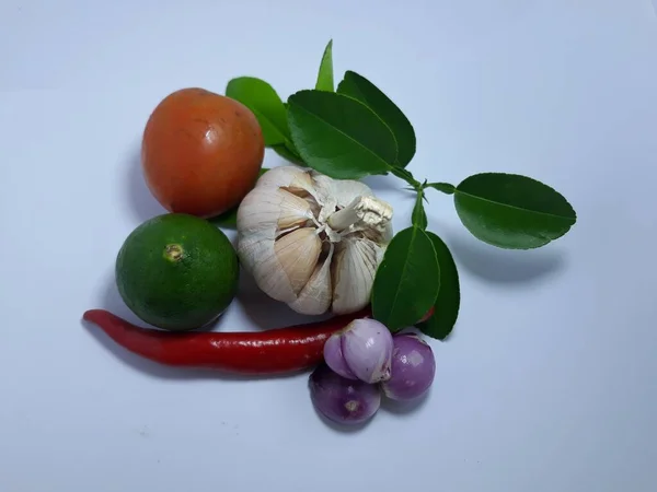 Close up isolated on white herbs, spices garlic, onion, chili, lime leaf and tomato on pink bowl with rice. Ingredient seasoning for cook food