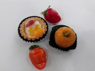 Çilek şeklinde beyaz kırmızı turuncu geleneksel Endonezya pastasına izole edilmiş.