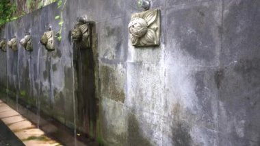 Taş duvardan sanatsal duş çeşmesi. Taş bir duvara yapışmış süs musluğu genellikle el, ayak ve yüzün yıkanması için kullanılır.