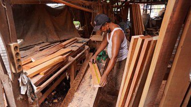 Surabaya, East Java, Indonesia - January, 2023 : furniture carpenters are smoothing wood blocks using a machine to make interior needs for homes and offices such as filling cabinets, tables, chair