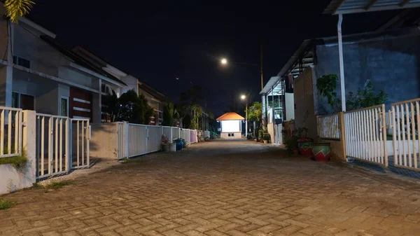 Night scenery empty lonely and tranquil paving street of residential house at rural village with Crescent moon               