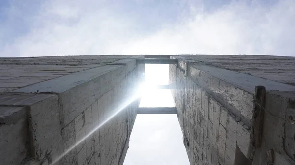 see the sun at noon through the gaps of the two buildings. sunlight silhouette between building wall