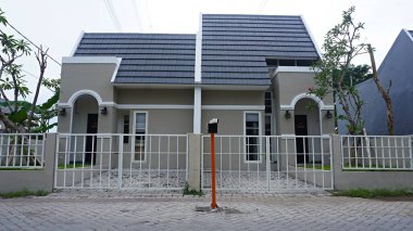 Surabaya, Java, Indonesia - January, 2023 : Close up a modern of house building surrounded by trees at residential rural village  