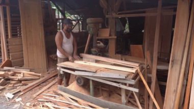 Surabaya, East Java, Indonesia - January, 2023 : furniture carpenters are smoothing wood blocks using a machine to make interior needs for homes and offices such as filling cabinets, tables, chairs