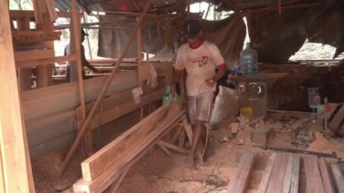 Surabaya, East Java, Indonesia - January, 2023 : furniture carpenters are smoothing wood blocks using a machine to make interior needs for homes and offices such as filling cabinets, tables, chairs