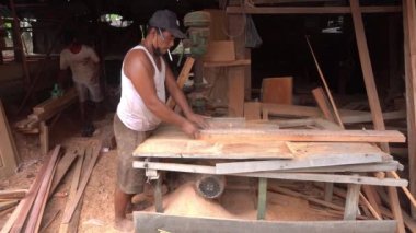 Surabaya, East Java, Indonesia - January, 2023 : furniture carpenters are smoothing wood blocks using a machine to make interior needs for homes and offices such as filling cabinets, tables, chairs