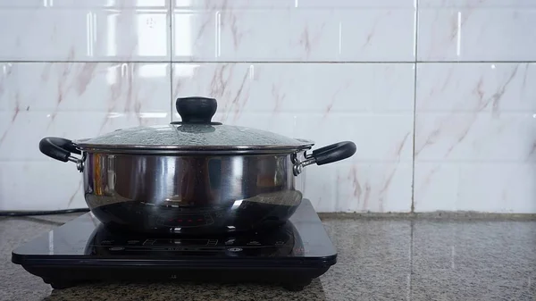 electric stove with a boiling pot on a ceramic background in the kitchen  