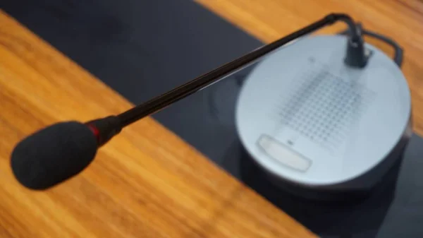 Selective focus concept and idea of a table mic microphone in a meeting room for business meeting seminars and teleconferences            