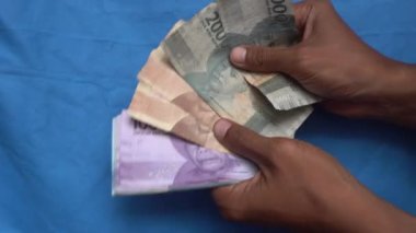 Business and financial activity of people counting Indonesian bank note rupiah money
