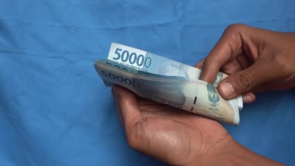 인도네시아 화폐를 계산하는 사람들의 — 비디오
