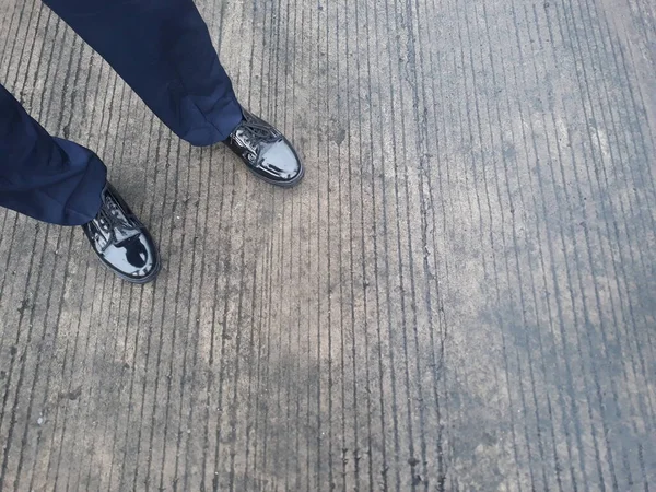 feet in formal work shoes with cement background