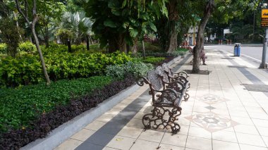 public benches on the side of the road or sidewalk  