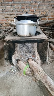 Geleneksel odun sobası ve içinde odun yığını var.