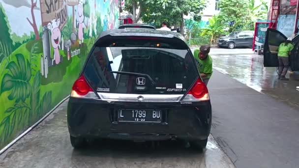 男人在洗车服务中擦拭一辆黑色汽车 印度尼西亚东爪哇 苏拉巴亚 2022年12月4日 — 图库视频影像