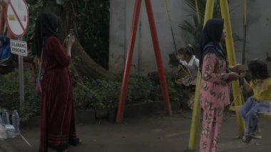 Salıncak oynayan çocuk. Surabaya, Doğu Java, Endonezya. 01 Ocak 2023