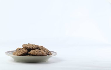 Beyaz arka planda ilanınız için fotokopi alanı olan bir sürü kurabiye. Beyaz arka planda izole edilmiş tereyağlı çikolatalı kurabiyeler. Tatlı bisküviler. Ev yapımı pasta..