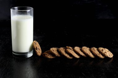 Siyah arka planda kurabiye ve süt. Metin için boşluk