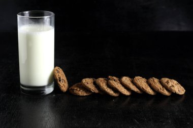 Siyah arka planda kurabiye ve süt. Metin için boşluk