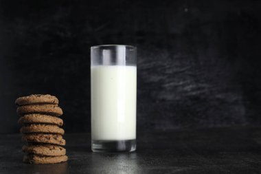 Siyah arka planda kurabiye ve süt. Metin için boşluk