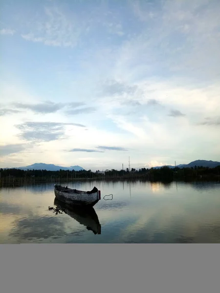 Traditional wooden boat floating on the waters of Lake Limboto, Gorontalo, Indonesia. Small wooden rowboat on a calm lake