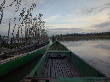Limboto Gölü, Gorontalo, Endonezya 'nın sularında yüzen geleneksel ahşap tekne. Sakin bir gölde küçük tahta bir kayık.