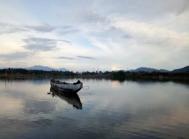 Limboto Gölü, Gorontalo, Endonezya 'nın sularında yüzen geleneksel ahşap tekne. Sakin bir gölde küçük tahta bir kayık.