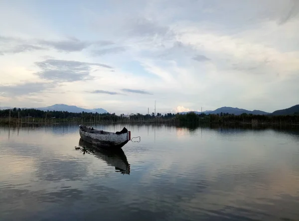 stock image Traditional wooden boat floating on the waters of Lake Limboto, Gorontalo, Indonesia. Small wooden rowboat on a calm lake