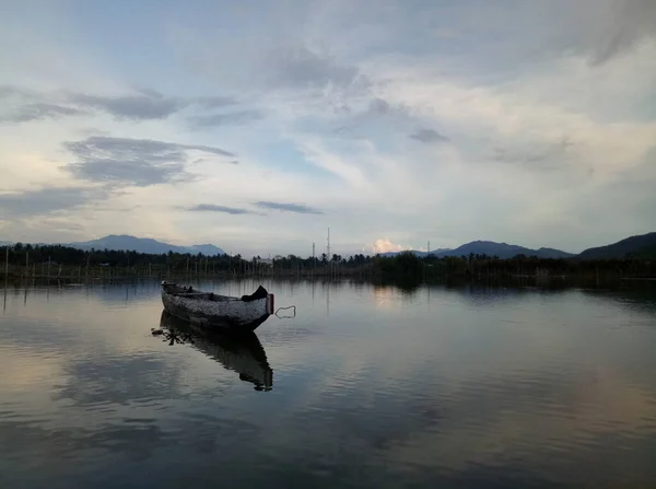 Traditional wooden boat floating on the waters of Lake Limboto, Gorontalo, Indonesia. Small wooden rowboat on a calm lake