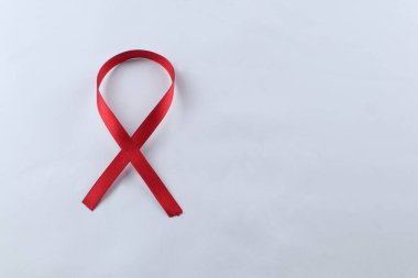 Kırmızı Destek Kurdelesi beyaz arkaplanda izole edildi. Dünya yardımları günü, ulusal HIV / AIDS ve yaşlanma ayını kırmızı kurdeleyle karşılıyor. kopyalama alanı