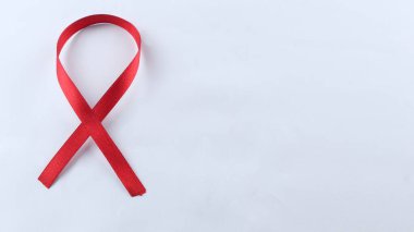 Kırmızı Destek Kurdelesi beyaz arkaplanda izole edildi. Dünya yardımları günü, ulusal HIV / AIDS ve yaşlanma ayını kırmızı kurdeleyle karşılıyor. kopyalama alanı