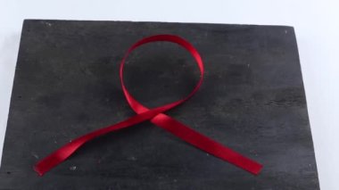 Kırmızı Destek Kurdelesi beyaz arkaplanda izole edildi. Dünya yardımları günü ve ulusal HIV / AIDS ve kırmızı kurdele ile yaşlanma farkındalığı ayı
